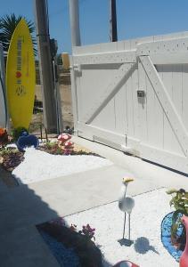 a white bird standing in front of a white gate at EcoChalé de Arraial in Arraial do Cabo