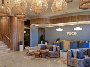 un vestíbulo con sofás, sillas y luces en voco Gosford by IHG, en Gosford