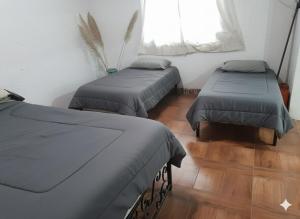 a room with two beds and a window at La Morada de sus Sueños Caeiro in Bialet Massé +3 photos