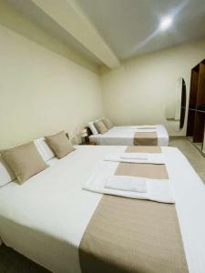 two beds in a room with two beds sidx sidx sidx at Studio 69 Aparthotel in Iquitos