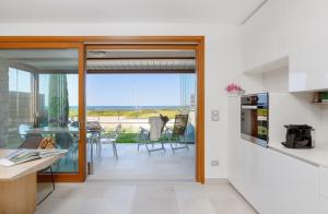eine Küche und ein Esszimmer mit Blick auf das Meer in der Unterkunft Portopiccolo Apartments - Giardino vista castello in Portopiccolo Sistiana