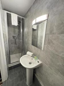 Un baño con lavabo y ducha en Princes Palace, en Londres 1 foto más