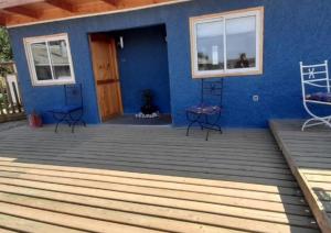 een blauw huis met een houten dek en een deur bij Espacio lagunillas Alojamiento in Lagunillas