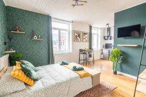 a bedroom with a bed and a green wall at Le Prestigieux - PROXIMITÉ IMMÉDIATE GARE VALENCIENNES I TRAMWAY I NETFLIX I IDÉAL ÉTUDIANT, SALARIÉ - ÉLÉGANT & CONFORT in Valenciennes