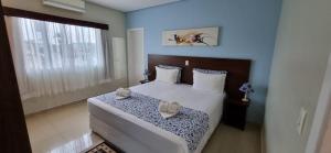 a bedroom with a bed with two slippers on it at Pousada Maré dos Sonhos in Itanhaém +51 photos