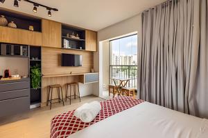 a bedroom with a bed and a kitchen with a window at Studio mobiliado ao lado do aeroporto de Congonhas in Sao Paulo +9 photos
