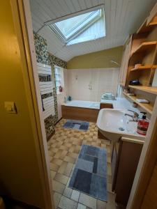 a bathroom with a sink and a bath tub at Gourmandise in Coutances