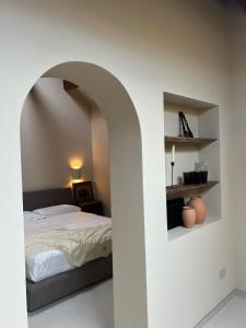 a bedroom with an archway with a bed and a desk at Suite Los Arcos in Chioggia