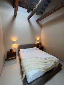 a bedroom with a large white bed with two lamps at Can Los arcos in Chioggia