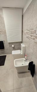 カターニアにあるShort Location Paratore Casa Melinaの白いトイレと洗面台のあるバスルーム +30枚の写真