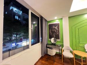 a room with green walls and a table and chairs at Venus apartment 45 in Hanoi +26 photos