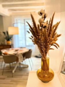 a vase filled with dried flowers on a table at Meilleur rapport qualité prix de la Région in Malicorne-sur-Sarthe