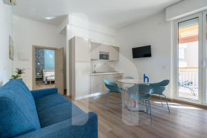 a living room with a blue couch and a table at Homiday - Residence Venere in Alba Adriatica