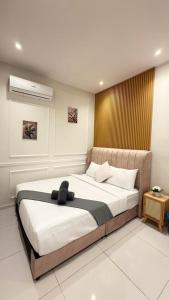 a bedroom with a bed with a black hat on it at Majestic Residence Suites KLCC in Kuala Lumpur +100 photos