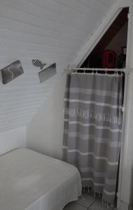 a room with a bed and a window with a curtain at Le studio du dolmen à Plouharnel in Plouharnel