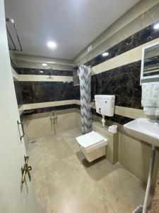 un baño con inodoro y lavabo en Home away from Home close to Swaminarayan Temple, en Nadiād