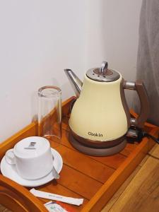 a tea kettle on a wooden table with a glass at AfterFly in Ahangama +34 photos