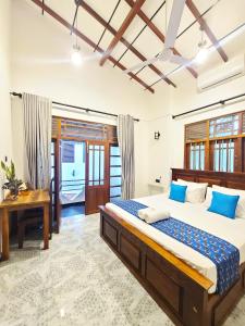 a bedroom with a large bed and a desk at AfterFly in Ahangama