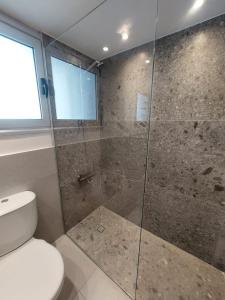 a bathroom with a shower with a toilet and a window at Beachfront Amazing New Apartment in Limassol