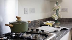 einen Topf auf einem Herd in einer Küche in der Unterkunft Wildflowers Cottage in Bourton on the Water