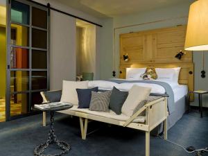 a bedroom with a bed and a couch and a table at 25hours Hotel Altes Hafenamt in Hamburg