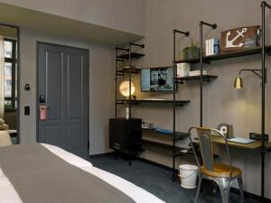 a bedroom with a bed and a desk and a chair at 25hours Hotel Altes Hafenamt in Hamburg