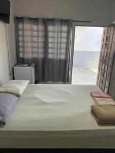 a large bed in a room with a large window at Suítes quintino in Uberlândia