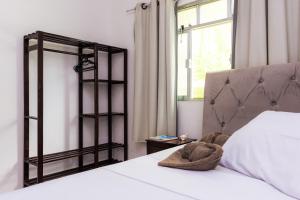 ein Schlafzimmer mit einem weißen Bett und einem Fenster in der Unterkunft Casa Quintal Economic - Pé na Areia - Araçatiba Ilha Grande in Praia de Araçatiba