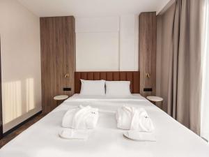 una camera da letto con un letto bianco con due asciugamani bianchi di Mercure Bialystok a Białystok