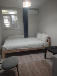een kleine slaapkamer met een bed en een stoel bij Şişli Suites - Room47 in Istanbul
