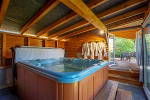 a large hot tub in a cabin with a deck at Camping Alsace Les Castors in Burnhaupt-le-Haut +270 photos