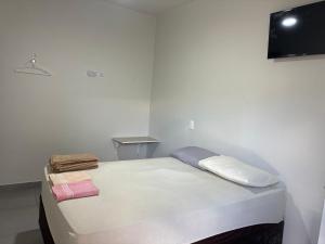 a bed with two towels on it in a room at Suítes quintino in Uberlândia