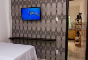 einen TV an der Wand in einem Schlafzimmer in der Unterkunft Casa Quintal Economic - Pé na Areia - Araçatiba Ilha Grande in Praia de Araçatiba
