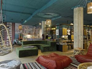 a living room with a green couch and ottoman at 25hours Hotel The Trip in Frankfurt/Main