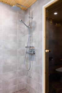 eine Dusche mit Duschkopf in einem Badezimmer in der Unterkunft Halla Chalet, Northern Lights, ski & lake, free wifi, Vuosseli Resort Ruka in Kuusamo