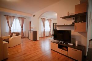 a living room with a couch and a television at Csilla Vendégház Remete in Remetea