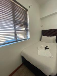 a bedroom with a white bed with a window at Lookout 12 Duminy Guesthouse in Avondale