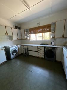 a kitchen with a washing machine and a washer at Lookout 12 Duminy Guesthouse in Avondale