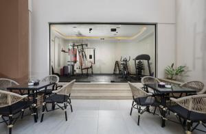 a dining room with tables and chairs and a gym at Rivana Residence New Cairo - Pool & GYM Access in Cairo
