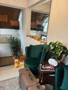 a living room with a green chair and a table at Hotel Garni Expo in Banská Bystrica