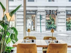 a restaurant with a table and chairs in front of a store at Mercure Roma Centro Termini in Rome