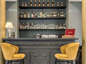 a bar with two chairs and bottles of alcohol at Mercure Roma Centro Termini in Rome
