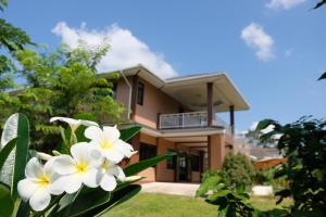 a house with white flowers in front of it at K Garden Homestay Chiang Rai 