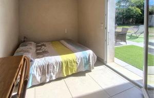a bedroom with a bed and a sliding glass door at Maison Près De La Mer in LʼAiguillon-sur-Mer