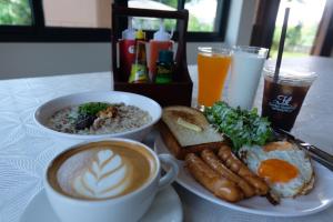 a table with a plate of breakfast food and a cup of coffee at K Garden Homestay Chiang Rai 