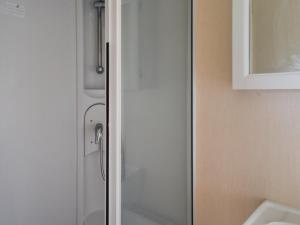 a glass door of a shower in a bathroom at Praise Machine Caravan Experience in Jaywick Sands