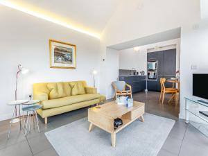 a living room with a yellow couch and a table at Taigh Glas in Big Sand