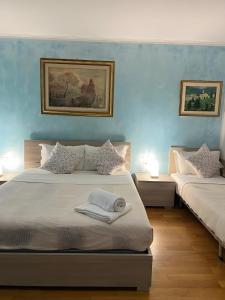 1 dormitorio con 2 camas y paredes azules en Venice casa, en Mestre
