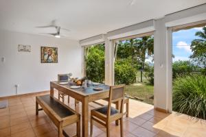 a dining room with a table and chairs and sliding glass doors at Appartement Aloé - Jardin et accès plage direct in Le Carbet +15 photos