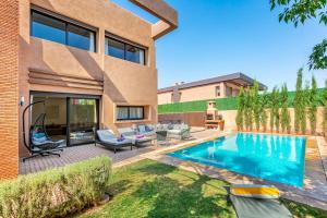 ein Hinterhof mit einem Swimmingpool und einem Haus in der Unterkunft Comfortable villa with heated pool in Marrakesch